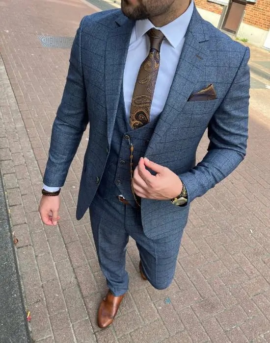 Homme en costume trois pièces bleu avec cravate élégante