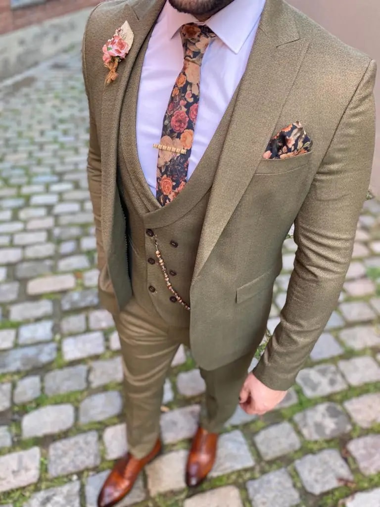 Homme en costume trois pièces olive avec cravate fleurie