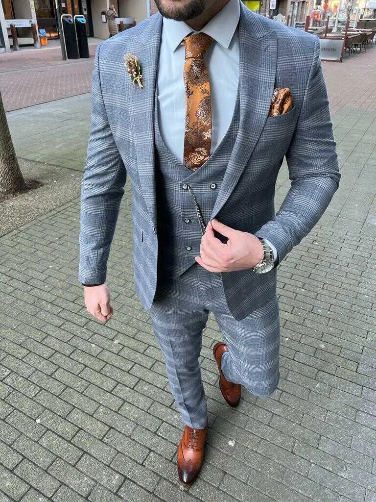 Homme en costume trois pièces gris avec cravate orange