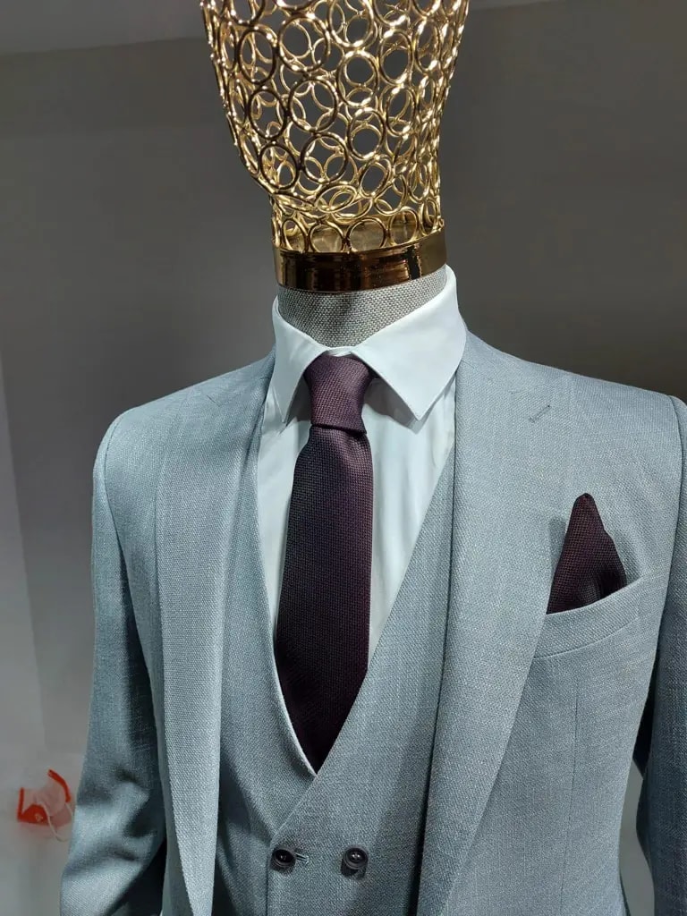 Stijlvol lichtblauw pak met paarse stropdas en pochet