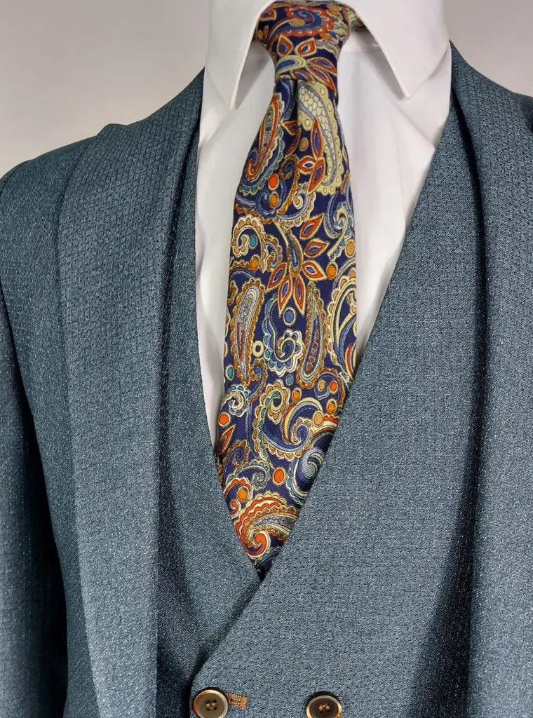 Costume élégant bleu avec cravate à motifs colorés