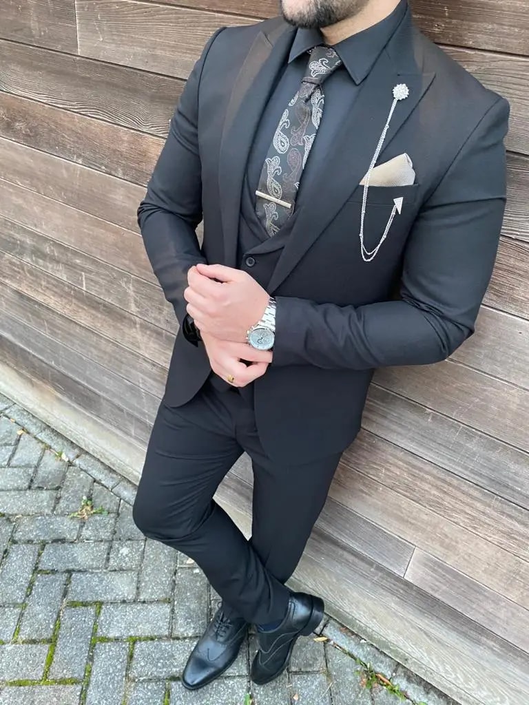 Homme en costume élégant noir avec cravate et accessoires