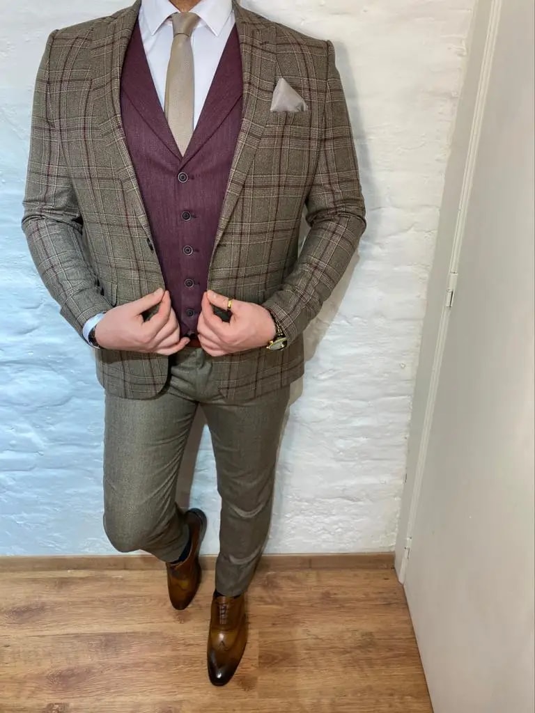Homme en costume à carreaux marron avec gilet bordeaux